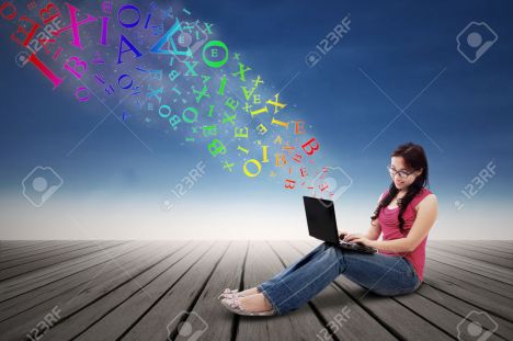 23181442-Asian-girl-using-a-laptop-computer-from-which-coming-out-alphabets-outdoor-Stock-Photo.jpg